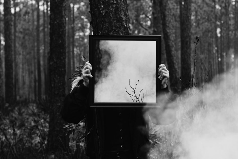 Person im Wald mit Spiegel in den Händen